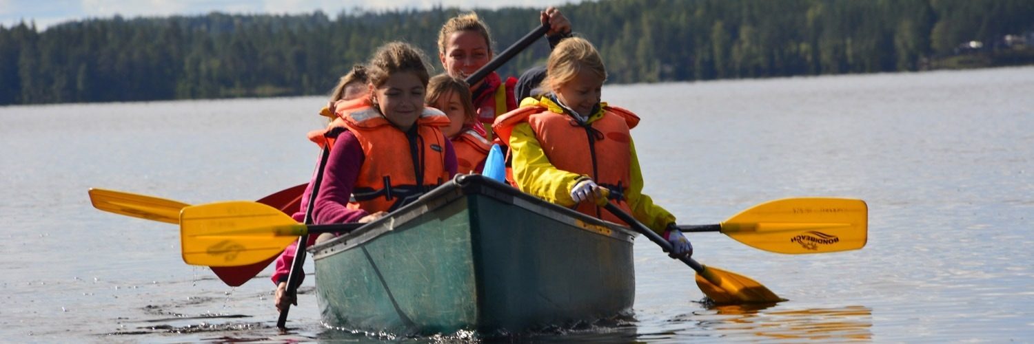 Kinder sind in einem Kanu und paddeln über den See