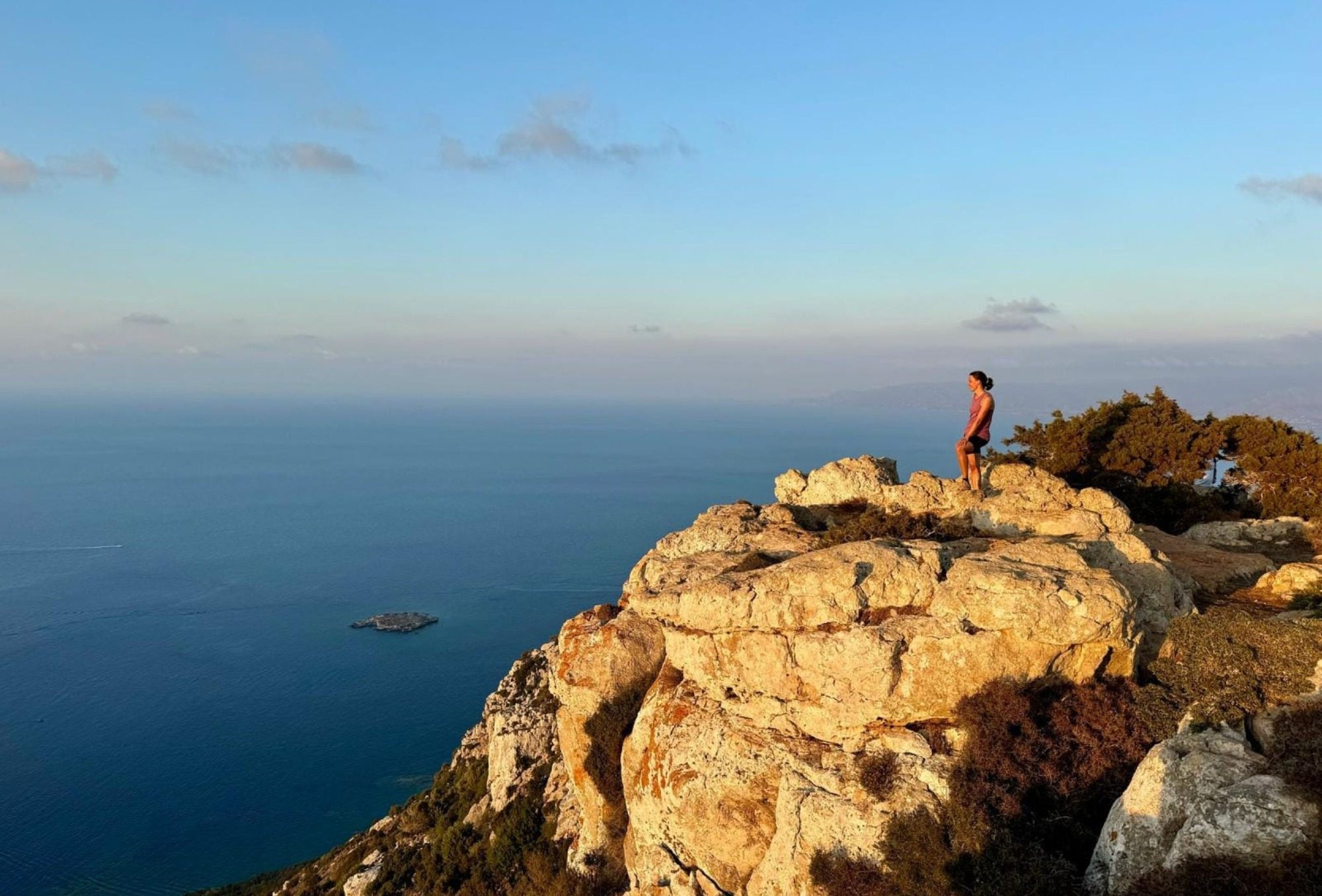 Frau auf einem Felsen an der Küste Zyperns