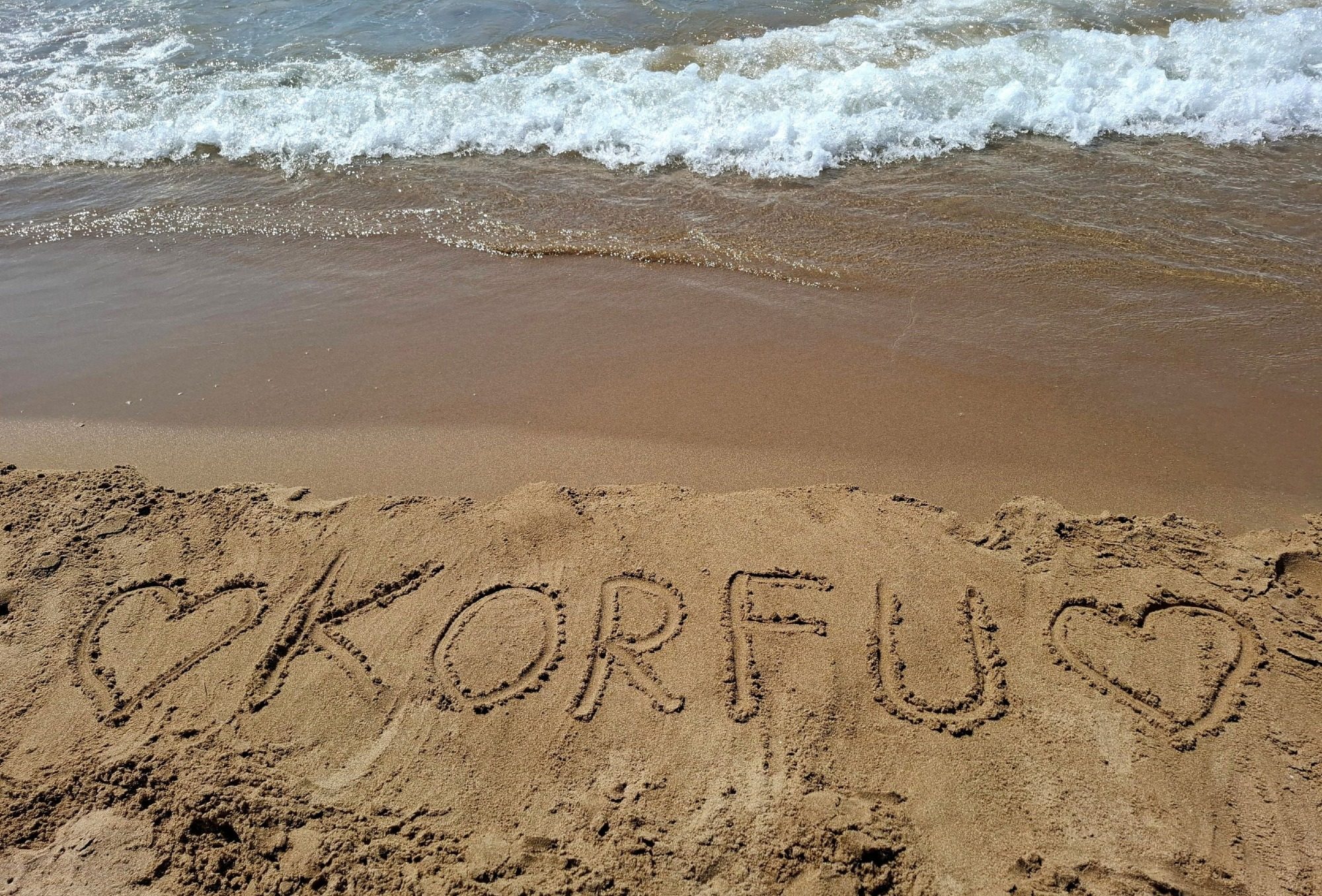 Schriftzug Korfu im Sand