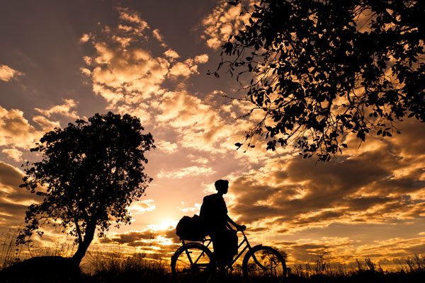 Krankenschwester Royce aus Sambia steht vor Sonnenaufgang auf um ihre Patienten zu betreuen. Dank Fahrrad kann sie sich um 18 statt früher 4 Haushalte kümmern.