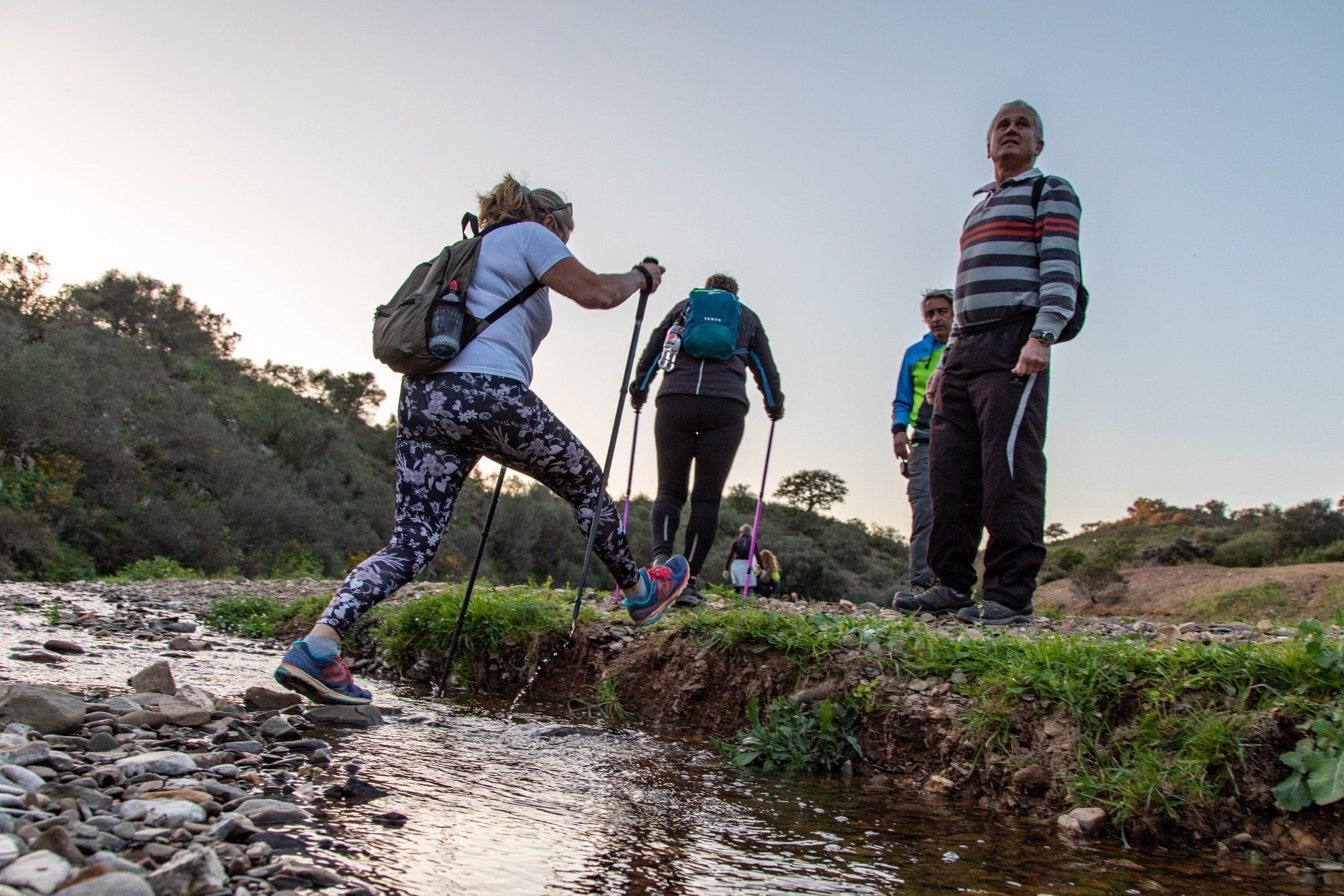 Wanderer steigen über einen kleinen Bach